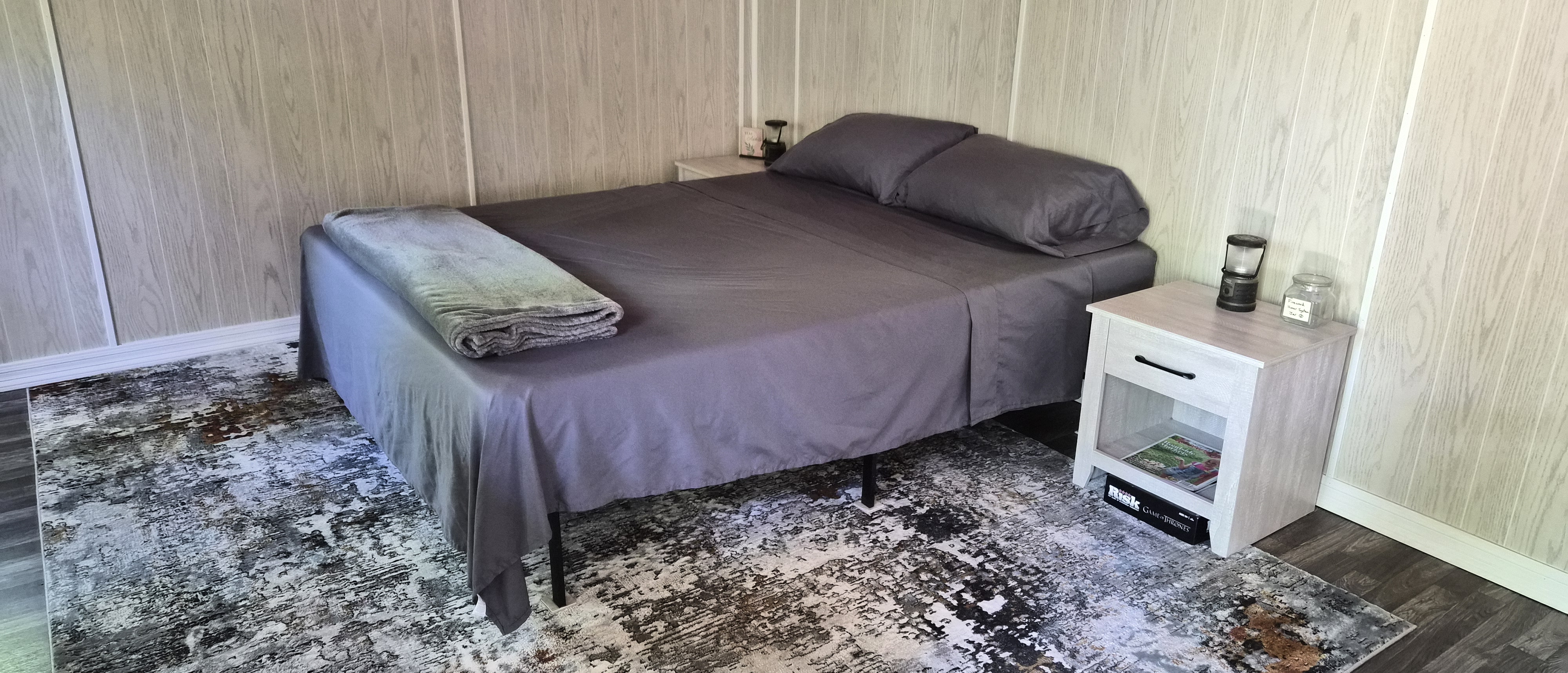 Queen bed with colorful woodland bedding inside the cabin