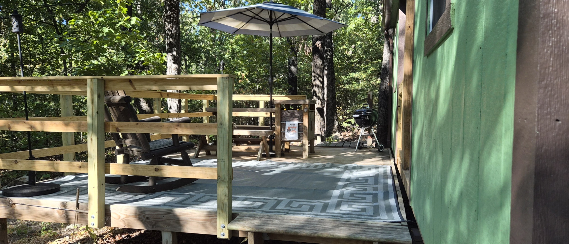 Side view of the finished cabin deck and railing in the woods