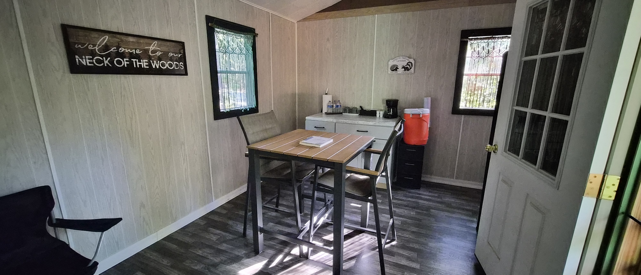 Dining table, coffee station, drinking water, and macramé curtains inside the cabin